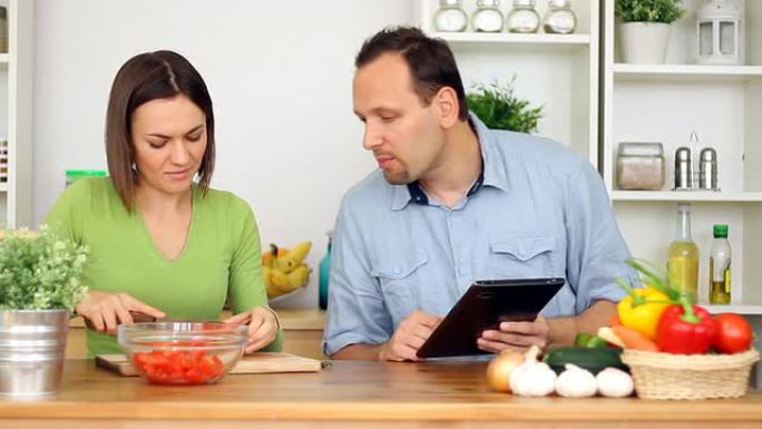 夫妇在烹饪过程中使用平板电脑