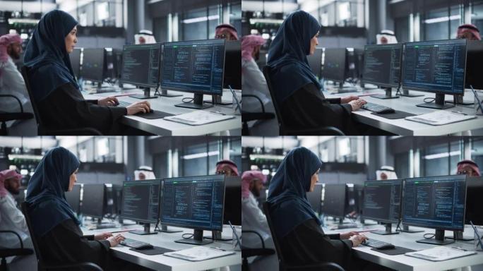 中东女性在一家专业技术企业的阿拉伯男性公司工作。年轻的中东专家在台式计算机上编写高级软件代码