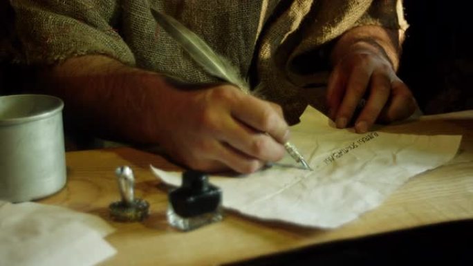 一个人用羽毛的墨水笔写字