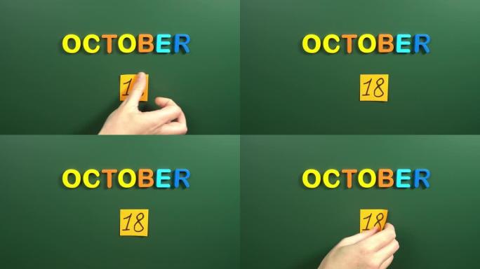 10月18日日历日用手在学校董事会上贴一张贴纸。18 10月日期。10月的第十八天。第18个日期编号