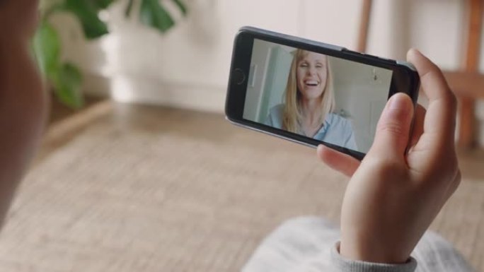 年轻女子在家中使用智能手机进行视频聊天，与朋友聊天，享受对话，在手机上分享生活方式