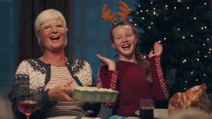 祖母享受圣诞晚餐，孙女吃美味的自制餐，与家人在家分享节日盛宴4k镜头