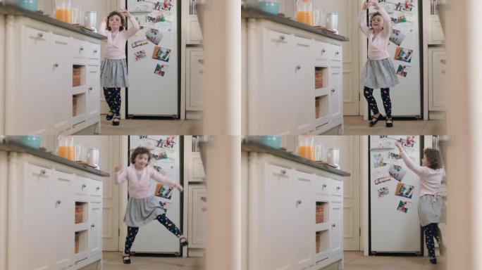 快乐的小女孩在厨房跳舞，玩得开心，在家享受周末的有趣舞蹈动作
