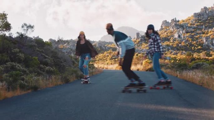 快乐的多民族朋友一起骑滑板在乡村路上巡航玩得开心，享受轻松的暑假