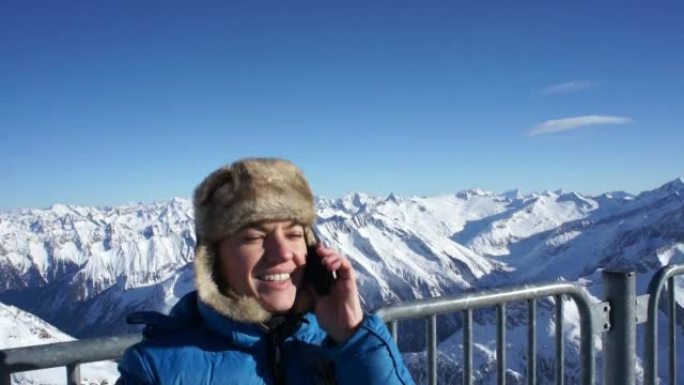 迷人的女人在山上用手机聊天
