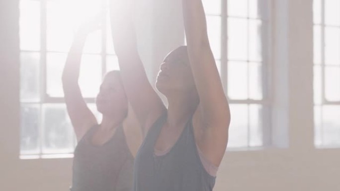 年轻的怀孕混血儿女子在瑜伽课上练习战士姿势享受健康的生活方式团体在日出时在健身工作室锻炼