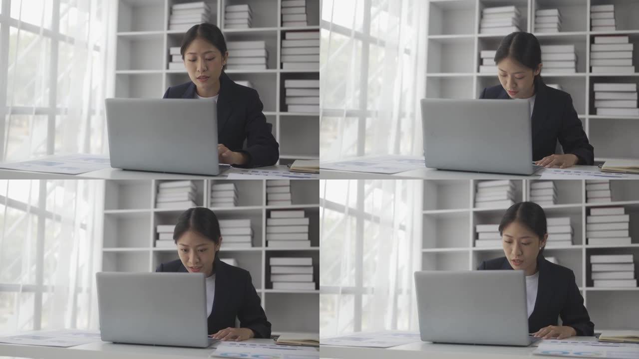 亚洲女会计师坐在办公桌前计算每月开支使用计算器检查公用事业账单管理家庭预算会计师从事文书工作