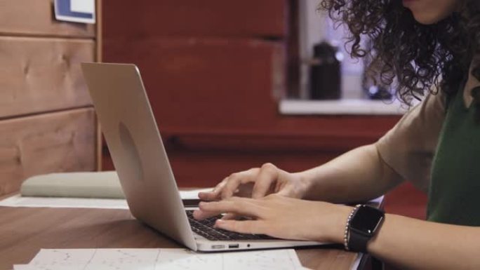 匿名女性在笔记本电脑上打字的手
