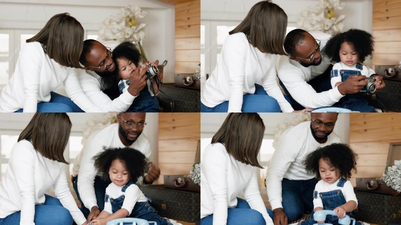 多种族的新手父母正在照顾他们的女儿，而她的父亲正在教她如何使用相机。