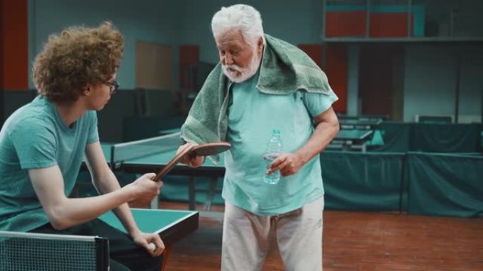 老乒乓球运动员教一名少年如何握拍