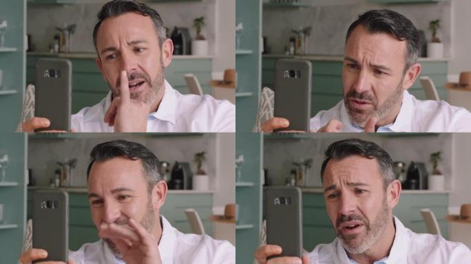 有吸引力的男人拿着智能手机进行视频聊天，使用手语挥舞着享受手机上的连接聊天