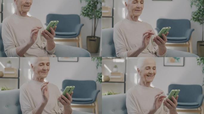 快乐的老年女士慢动作肖像使用智能手机触摸屏在家室内享受内容