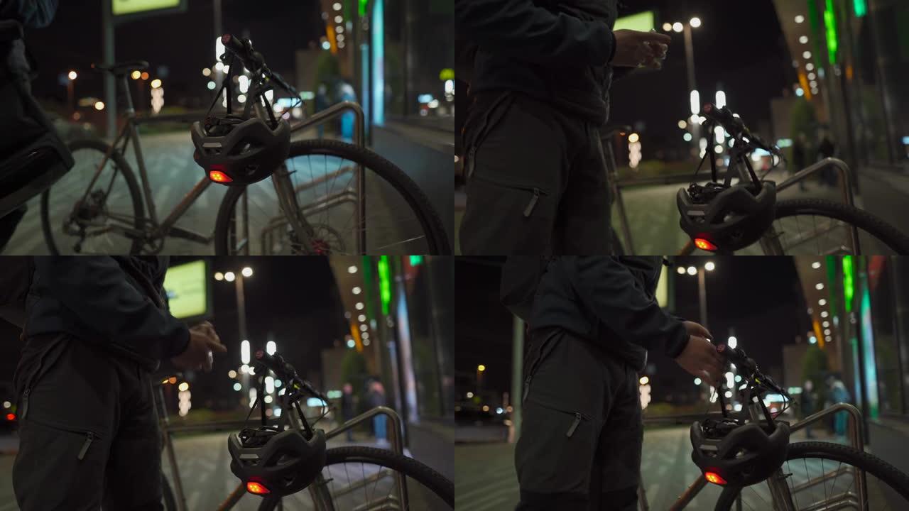 戴着医用口罩的骑自行车的人从商店出来，步行到停放的自行车用消毒剂治疗他的手，晚上在城市戴上带有红色闪