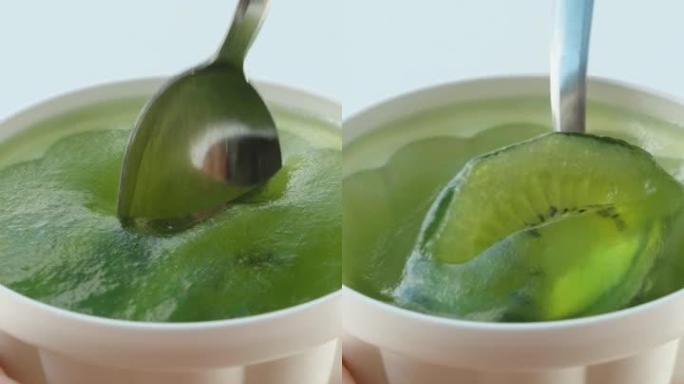 垂直。我吃猕猴桃的绿色果冻，用勺子舀起，特写镜头。