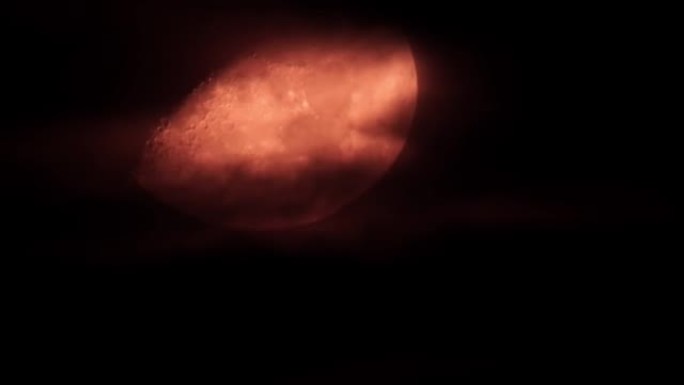 发光的红色神秘月亮穿过乌云和夜空。神奇神秘的月夜。万圣节巫术情绪。