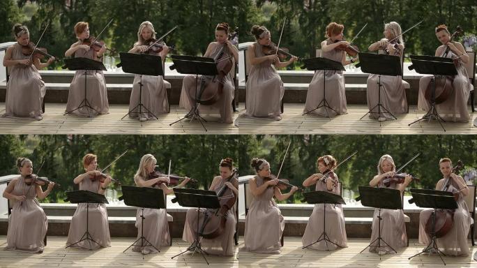 音乐四重奏。三位小提琴家和大提琴家演奏音乐。