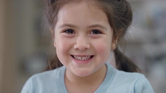 肖像美丽的小女孩微笑着看着相机可爱的孩子带着顽皮的表情享受快乐的童年4k