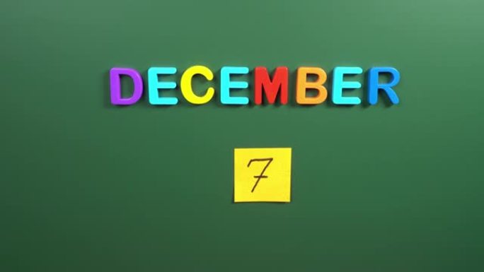 12月7日日历日用手在学校董事会上贴一张贴纸。7 12月日期。12月的第七天。第7个日期号。7天日历