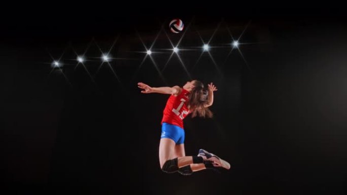 身穿红色球衣的SLO MO女子排球运动员跳空击球