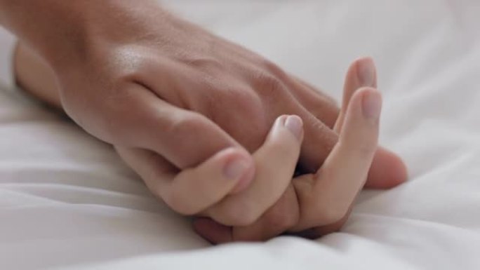 特写年轻夫妇手牵手躺在床上一起享受浪漫关系4k镜头
