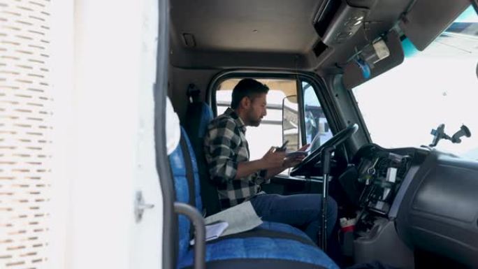 拉丁美洲卡车司机在看文书工作时在车内的对讲机上聊天