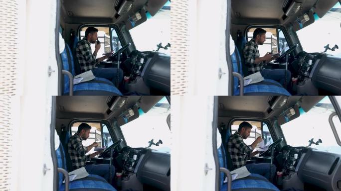 拉丁美洲卡车司机在看文书工作时在车内的对讲机上聊天