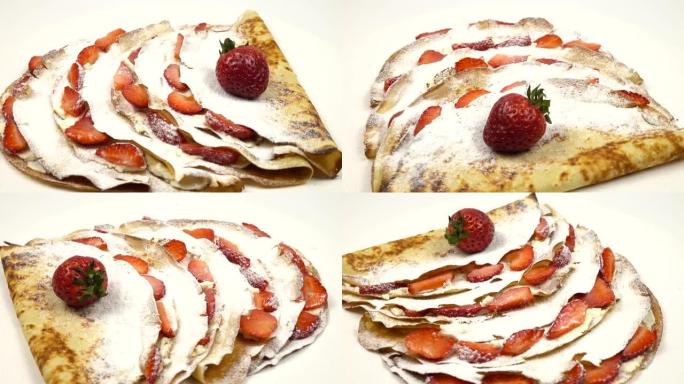 薄饼，上面撒上糖粉，对折并用草莓装饰