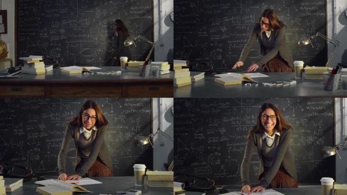 大学教室里年轻女教师的肖像，使用笔记和带有数学公式的黑板工作。在大学图书馆学习的理科生看着相机微笑