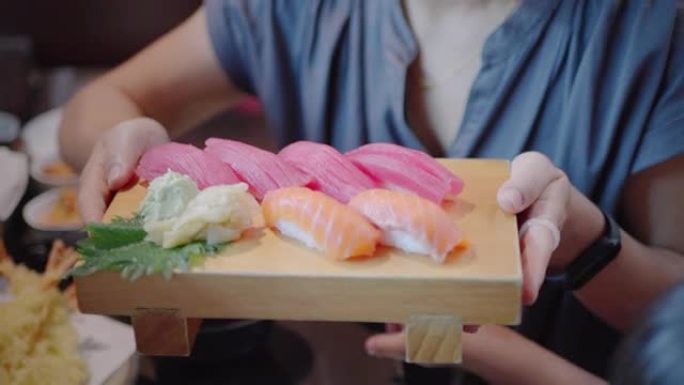 木托盘日本餐厅手持寿司的女性特写