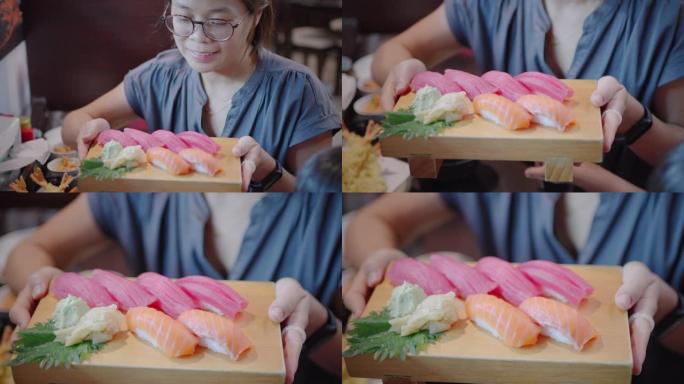 木托盘日本餐厅手持寿司的女性特写