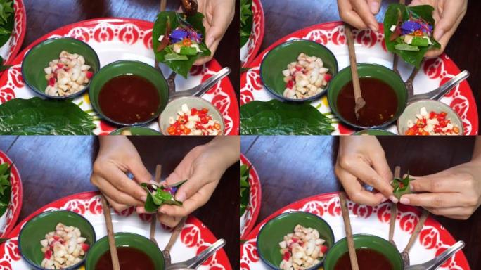木勺将酱汁倒入槟榔叶中的多种蔬菜，然后将其包装成皇家叶包裹开胃菜或 “Miang kham”，这是泰