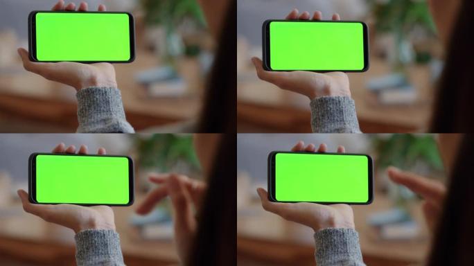 使用智能手机绿屏的女人在色度键上向婴儿挥手视频聊天母亲在水平方向上享受手机通信显示4k