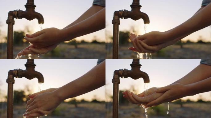 日出时，关闭妇女在农村农田用淡水在水龙头下洗手