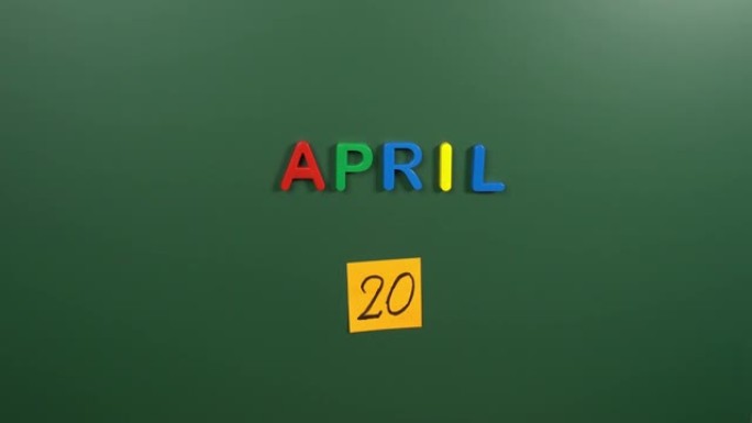 4月20日日历日用手在学校董事会上贴一张贴纸。20 4月日期。4月的第二十天。第20个日期号。20天
