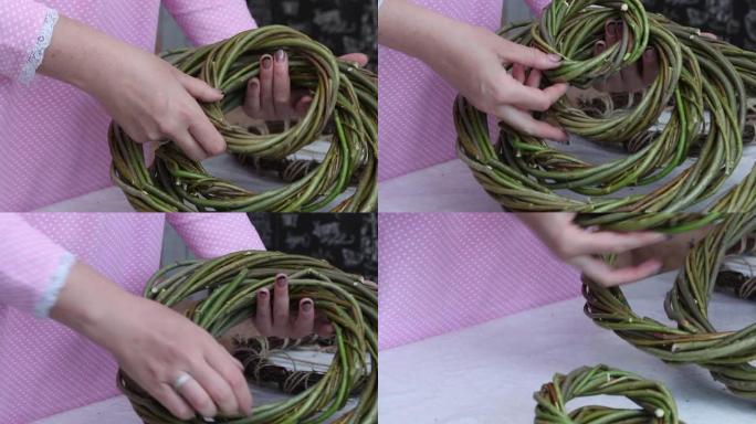一个女人把用藤蔓编织的自制花环放在一起。各种大小的花环。特写。