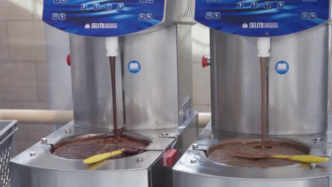热牛奶巧克力在工厂流动或流动，慢动作