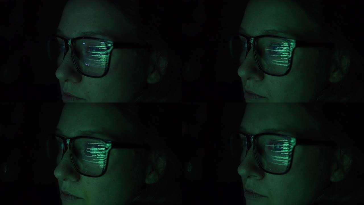 女黑客程序员在黑暗中分析数据的特写，眼镜上是笔记本电脑或电脑屏幕上程序代码的绿色反射，黑客系统和数据