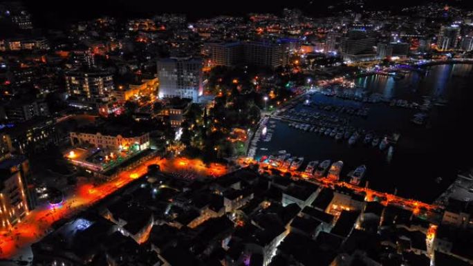 夜城，在黑山山脉的山坡和亚得里亚海附近的星空的背景下，设有电灯