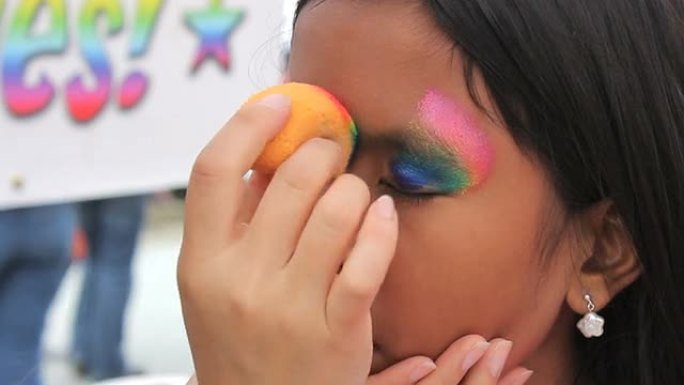 亚洲女孩得到彩虹脸画面具应用