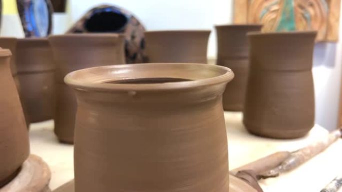 粘土工艺品陶器工作室木质桌子传统陶器成品在桌子上干燥，有盖和无盖