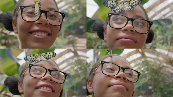 快乐的女孩微笑着，脸上带着蝴蝶飘动的翅膀，在自然保护动物园享受野生动物的乐趣，青少年生物学书呆子4k