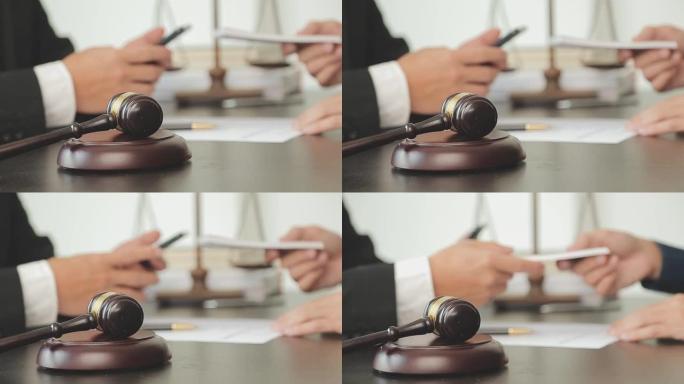 正义与法律概念。法律顾问向客户提交一份与木槌和法律法律或法律背景律师事务所团队会议的签署合同