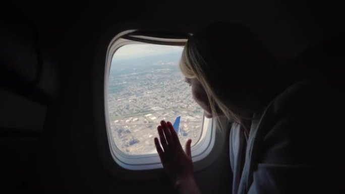 女人从客机的窗户往外看，看到大都市下面的地面