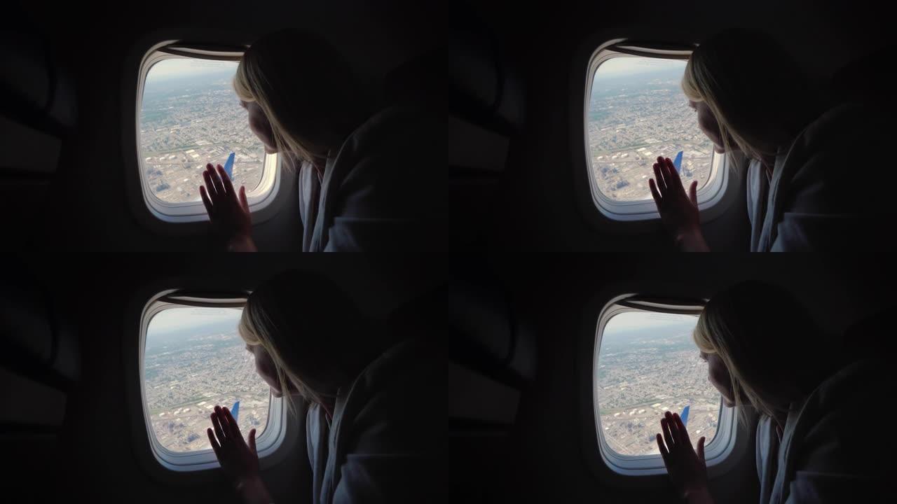 女人从客机的窗户往外看，看到大都市下面的地面