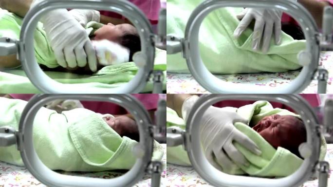 在孵化器中哭泣的新生婴儿在托儿所中照顾