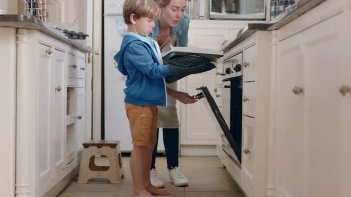 小男孩帮助母亲在厨房烘烤，把自制饼干放在烤箱里，戴着烤箱手套，享受新鲜美味的食物