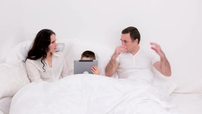 社交忽略，丈夫在平板电脑上在线观看社交时，妻子在床上感到不安。这是智能手机的脸或恐惧症综合症，关系概