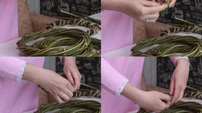 一名妇女检查用藤蔓编织的自制花环。固定柳条的末端。特写