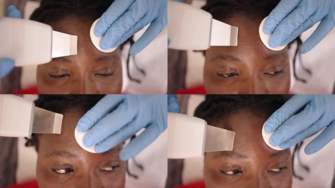 非裔美国妇女接受女性高加索美容师的超脱皮面部护理
