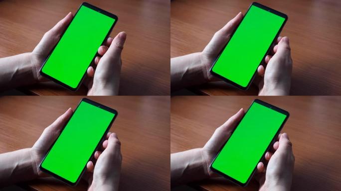 智能手机或色度键的绿色屏幕。女人的手握着手机，点击触摸屏。特写模拟